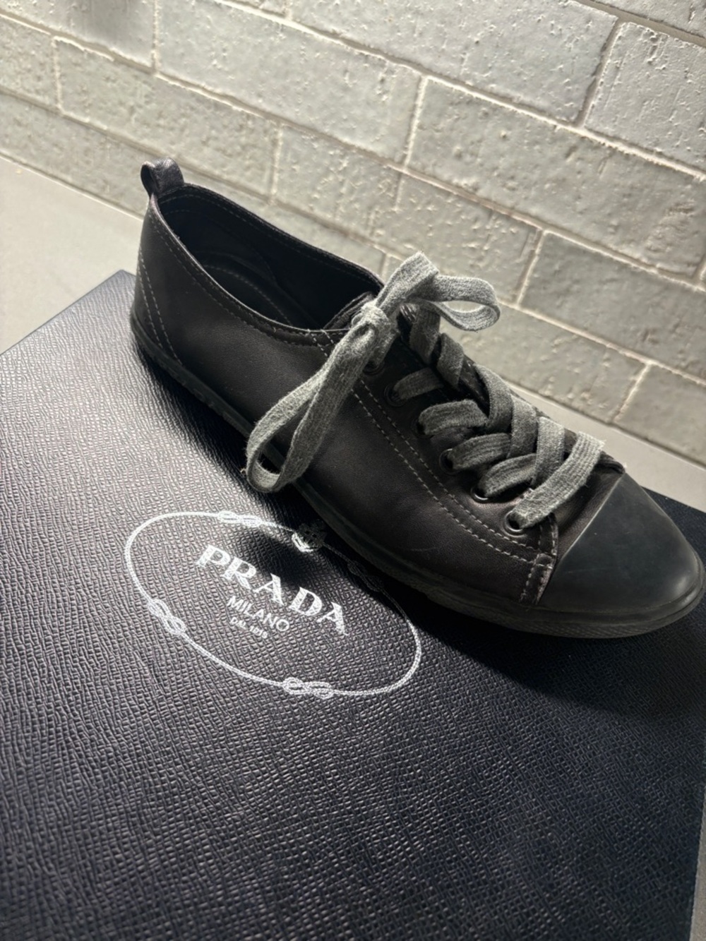 Prada women’s Low-Top Leather Sneaker in Charcoal Gray